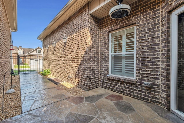 exterior space featuring brick siding, a patio area, and fence