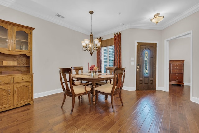 dining area with visible vents, ornamental molding, baseboards, a chandelier, and dark wood finished floors