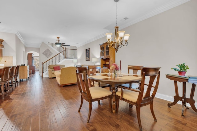 dining space with wood-type flooring, arched walkways, stairway, and ornamental molding
