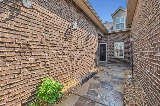 view of side of property featuring a patio and brick siding