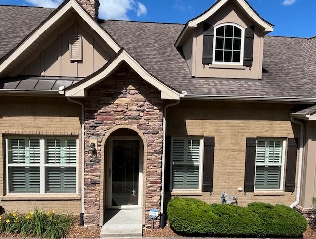 100 Placid Grove Ln Unit 2002, Goodlettsville, TN 37072 - doorway to property with a shingled roof, stone siding, a chimney, and board and batten siding