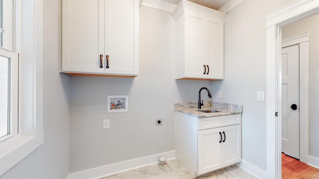 washroom with baseboards, cabinet space, electric dryer hookup, a sink, and washer hookup