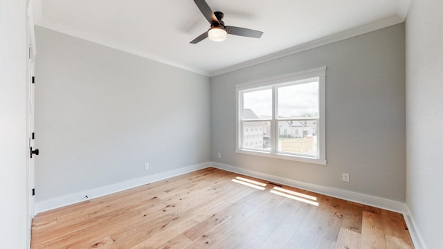 spare room with crown molding, a ceiling fan, baseboards, and light wood-style flooring