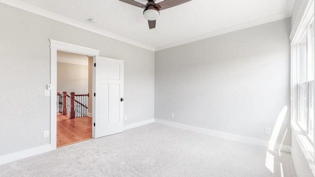 unfurnished bedroom featuring a ceiling fan, baseboards, ornamental molding, and carpet