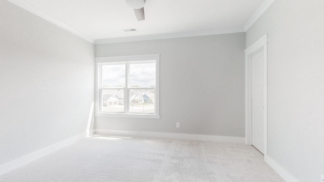 carpeted empty room with visible vents, ornamental molding, baseboards, and ceiling fan