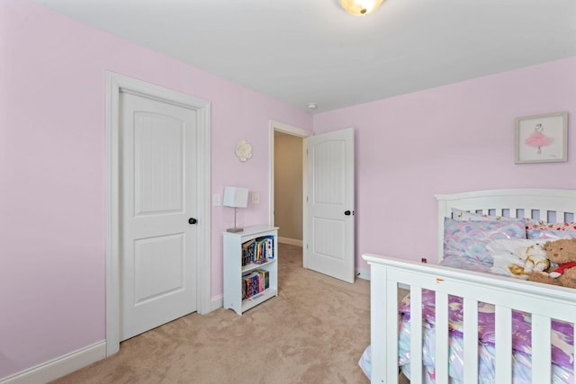 bedroom featuring baseboards and light carpet