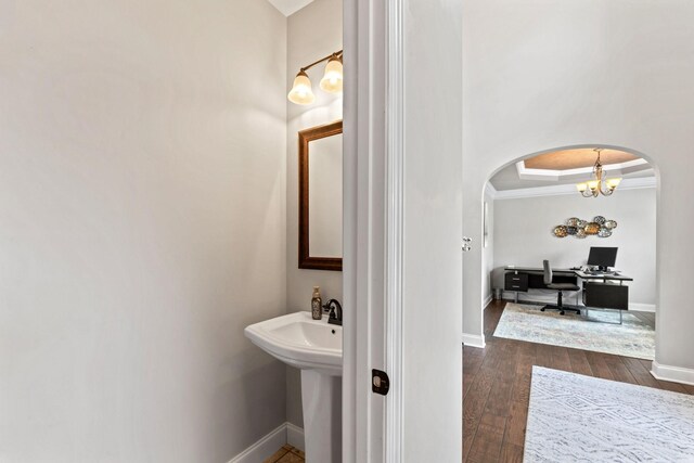 bathroom featuring baseboards, crown molding, and hardwood / wood-style floors