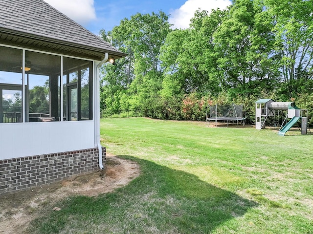 view of yard with a playground, a trampoline, and a sunroom