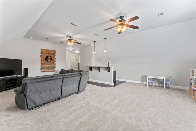 living room with visible vents, carpet floors, a ceiling fan, baseboards, and vaulted ceiling