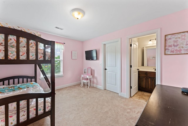 bedroom with baseboards, light colored carpet, connected bathroom, and visible vents