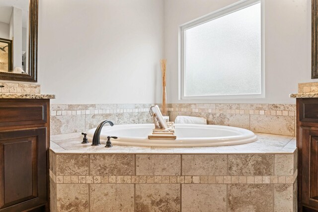 full bath featuring vanity and a garden tub