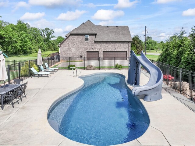 view of pool featuring fence, a water slide, a patio, and a fenced in pool