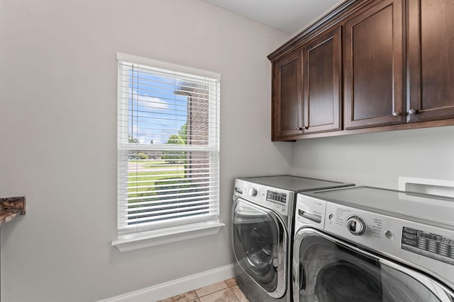 washroom with cabinet space, light tile patterned flooring, baseboards, and washer and clothes dryer