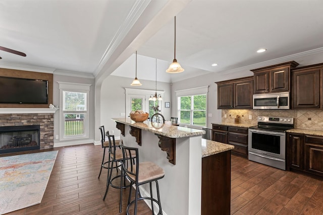 kitchen featuring appliances with stainless steel finishes, dark brown cabinetry, dark wood-style floors, and light stone counters