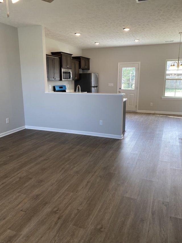 103 Glentree Cv, Smyrna, TN 37167 - kitchen featuring stainless steel appliances, dark wood-type flooring, dark brown cabinetry, baseboards, and a textured ceiling