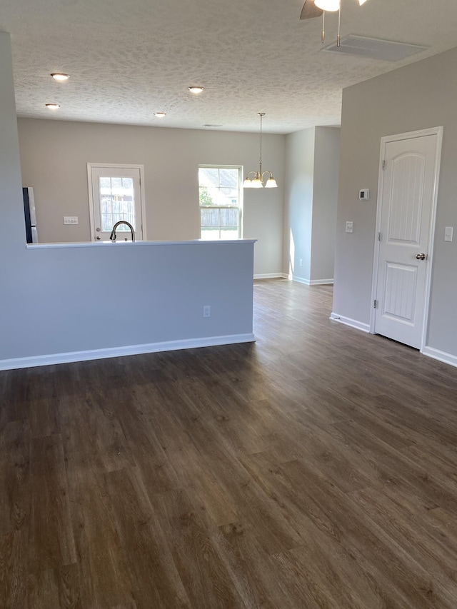 103 Glentree Cv, Smyrna, TN 37167 - unfurnished living room featuring a chandelier, dark wood-style flooring, a textured ceiling, baseboards, and recessed lighting