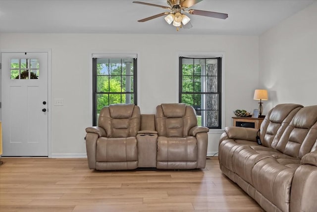 living room with baseboards, ceiling fan, a wealth of natural light, and light wood-style flooring
