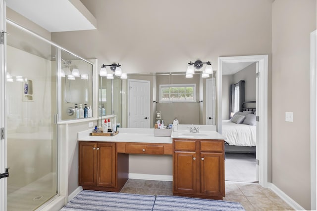 ensuite bathroom featuring a shower stall, vanity, baseboards, tile patterned floors, and ensuite bathroom