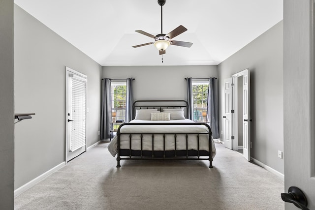 carpeted bedroom with baseboards, ceiling fan, vaulted ceiling, and multiple windows