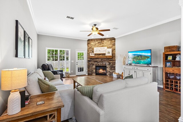 living room with dark wood-style flooring, a ceiling fan, visible vents, and a fireplace