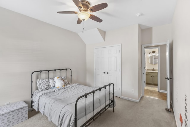 bedroom with ceiling fan, a sink, baseboards, a closet, and light carpet