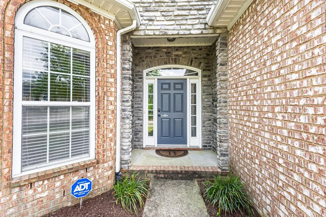 view of exterior entry with brick siding