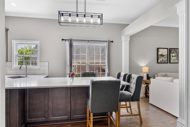dining space featuring recessed lighting, ornamental molding, decorative columns, and wood finished floors