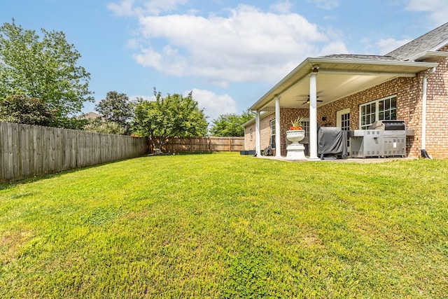view of yard with a ceiling fan and a fenced backyard