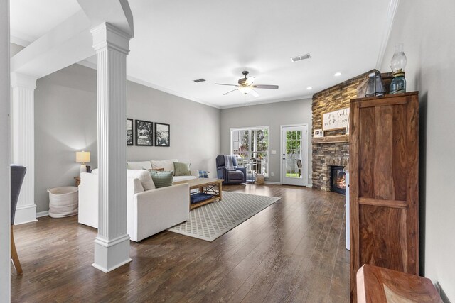 living room featuring a ceiling fan, decorative columns, dark wood finished floors, and visible vents