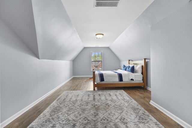 bedroom featuring baseboards, visible vents, dark wood-style floors, and vaulted ceiling