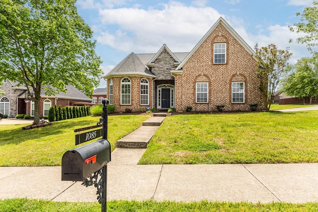 view of front facade with a front lawn and brick siding