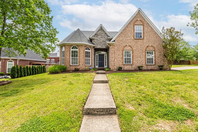 view of front of house with brick siding and a front yard