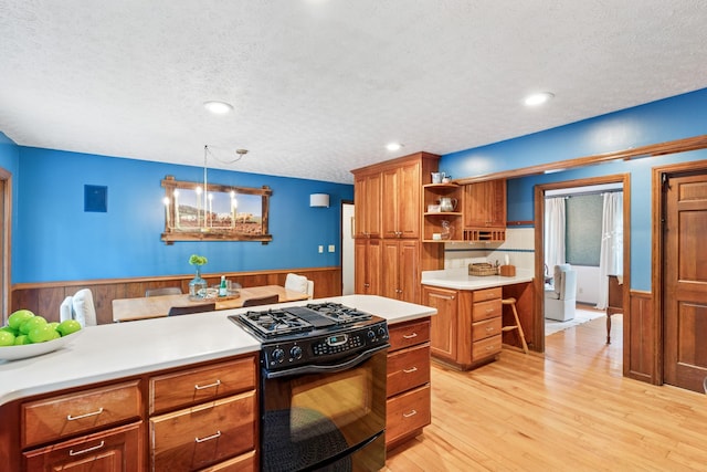319 Powder Mill Dr, Ashland City, TN 37015 - kitchen featuring brown cabinets, a textured ceiling, a wainscoted wall, and black range with gas stovetop