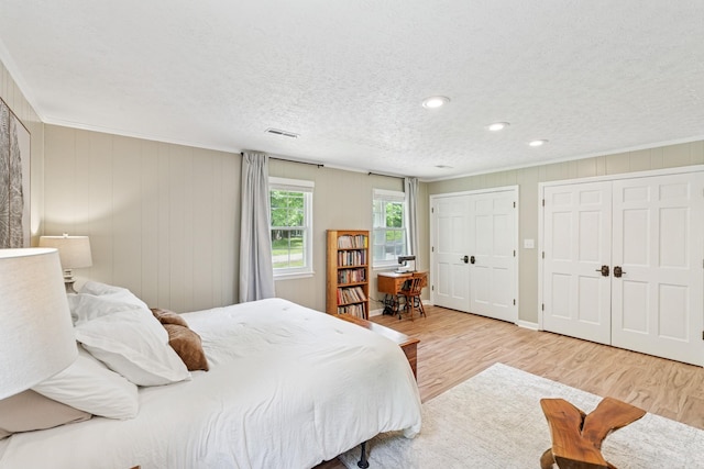 319 Powder Mill Dr, Ashland City, TN 37015 - bedroom with a textured ceiling, multiple closets, wood finished floors, visible vents, and ornamental molding