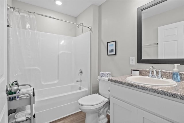 bathroom featuring vanity, shower / bath combo with shower curtain, toilet, recessed lighting, and wood finished floors