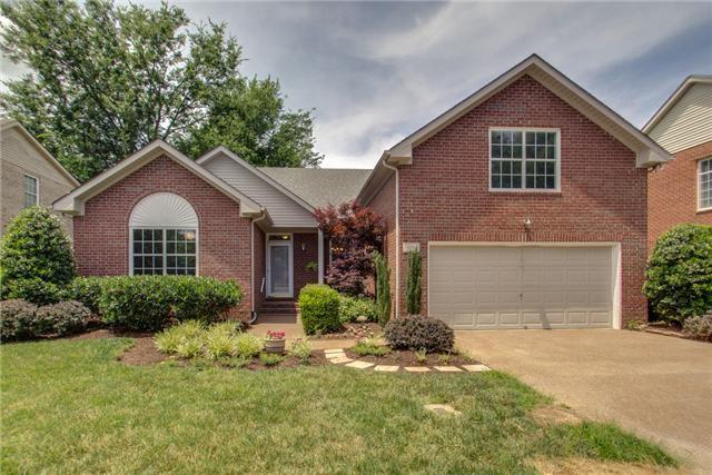 view of front of house with brick siding, a front lawn, an attached garage, and concrete driveway