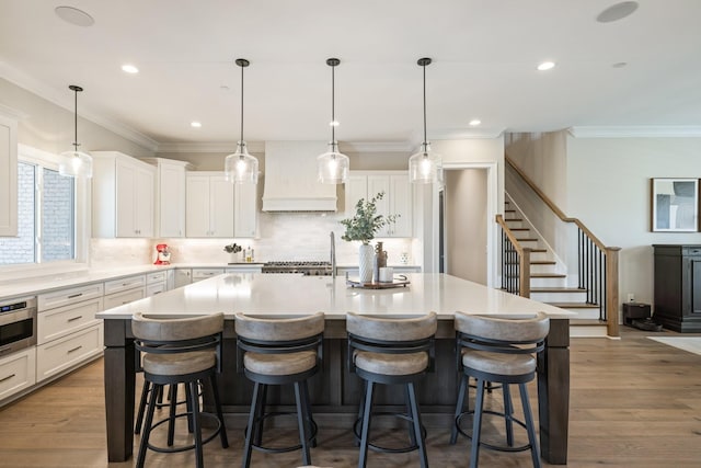 121 Dylan Woods Dr, Nolensville, TN 37135 - kitchen featuring crown molding, backsplash, custom range hood, and a kitchen bar