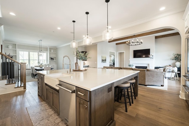 121 Dylan Woods Dr, Nolensville, TN 37135 - kitchen with dark brown cabinetry, stainless steel dishwasher, a sink, light countertops, and dark wood-type flooring