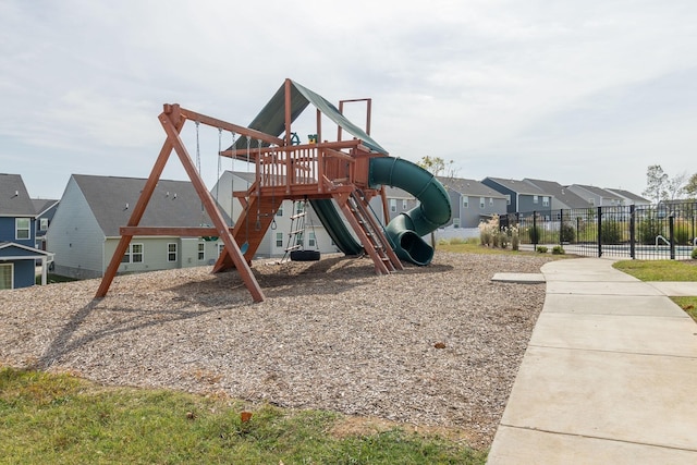 community playground featuring fence and a residential view