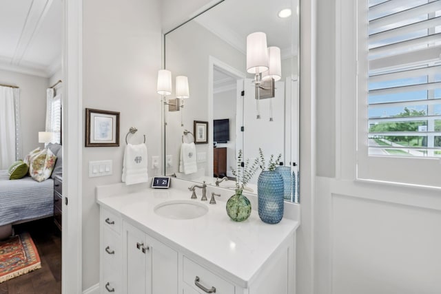 bathroom with crown molding, connected bathroom, wood finished floors, and vanity