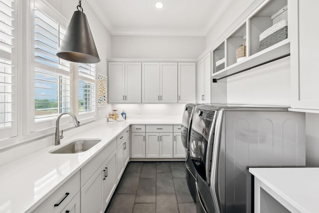 clothes washing area featuring ornamental molding, recessed lighting, separate washer and dryer, a sink, and cabinet space