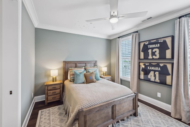 bedroom featuring crown molding, baseboards, visible vents, and wood finished floors