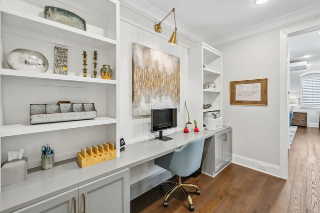 office with crown molding, built in desk, dark wood finished floors, built in shelves, and baseboards