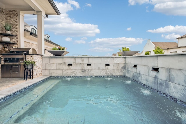 pool with area for grilling and an outdoor kitchen