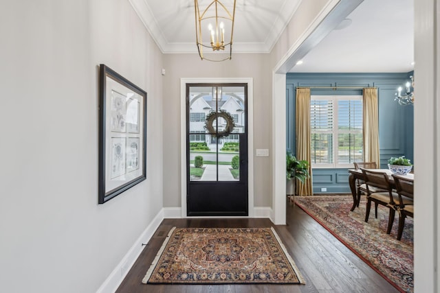 foyer with baseboards, a notable chandelier, dark wood-style floors, and ornamental molding