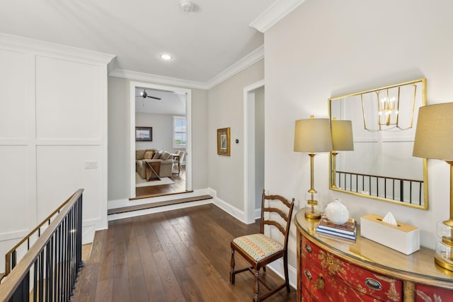 corridor featuring a notable chandelier, wood-type flooring, recessed lighting, baseboards, and ornamental molding