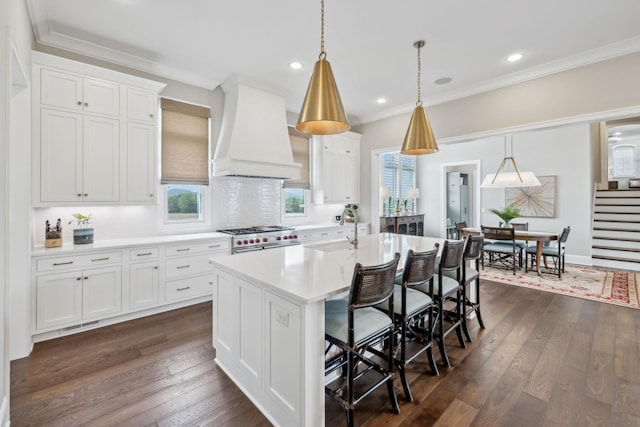 kitchen with light countertops, white cabinetry, a kitchen bar, custom exhaust hood, and high end stainless steel range oven
