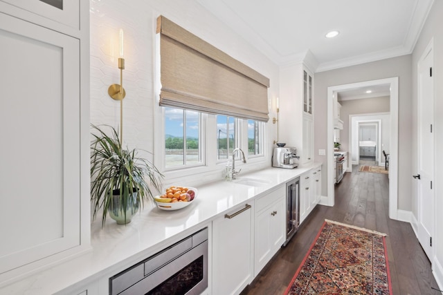 ensuite bathroom with ensuite bathroom, wood finished floors, wine cooler, ornamental molding, and recessed lighting