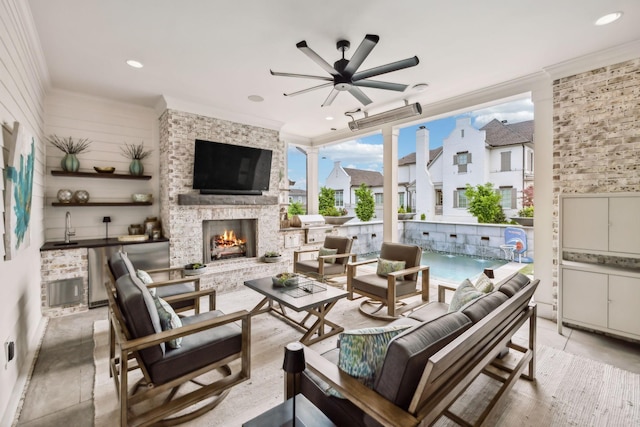 interior space with a ceiling fan, a lit fireplace, ornamental molding, and recessed lighting