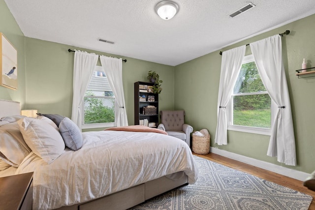 3610 Gleason Dr, Chattanooga, TN 37412 - bedroom with visible vents, a textured ceiling, baseboards, and wood finished floors